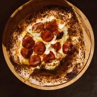 Pepperoni vista de cima, inteira, com a borda de gergelim tostada